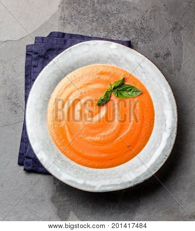 Traditional spanish andalusian tomato cream soup - salmorejo. Salmorejo or gazpacho cream soup on gray bowl, slate gray background.