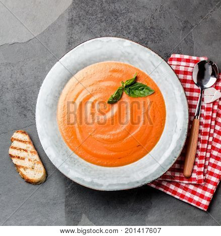 Traditional spanish andalusian tomato cream soup - salmorejo. Salmorejo or gazpacho cream soup on gray bowl, slate gray background.