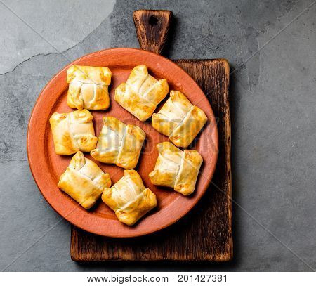 Mini chilean empanadas on clay plate with typical chilean drink vino con harina - red wine with toasted flour.
