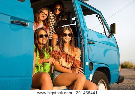 Summer holidays road trip vacation travel and people concept - smiling young hippie women in car