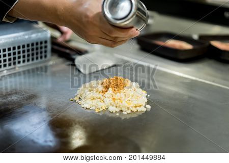 Hand Of Chef Cooking Garlic Fried Rice On Hot Pan In Front Of Customers.