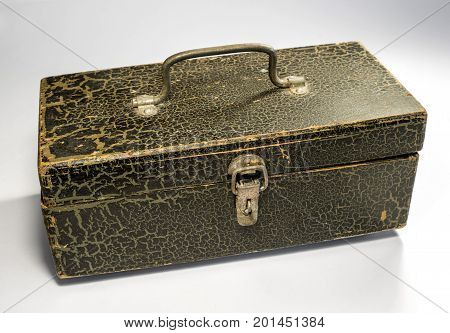 A wooden box with a metal handle and a latch on a light background. The box is painted with paint, the paint cracked with time. Retro.