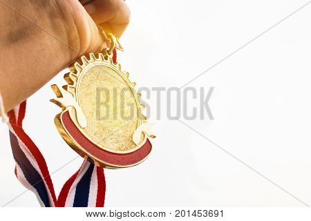 Winner hand holding golden medals to blur building background for show team success with their business Champion and Awards Concept