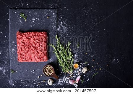 Raw meat beef steak on black background top view copy space.
