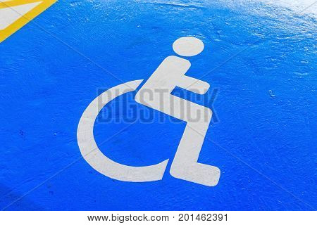 Handicap symbol on road traffic and pedestrians on parking space