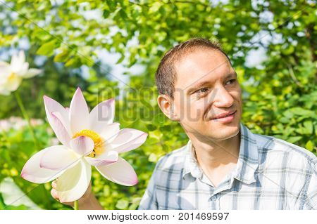 Portrait Closeup Of Young Man Smiling Holding Bright White And Pink Lotus Flower With Yellow Seedpod