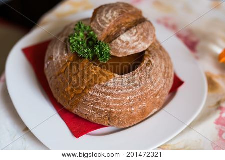 Goulash soup in bread served in a bread bowl.