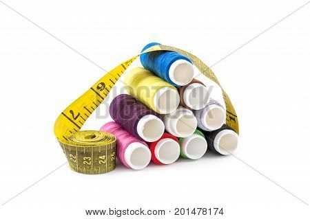 Sewing colored threads with measuring tape on white background.