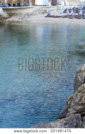 ULCINJ, MONTENEGRO - JULY 30, 2017: Small rock beach Liman on the Adriatic Sea in Ulcinj, Montenegro. Early morning time with empty beach beds, closed umbrellas and without people.