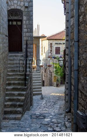 ULCINJ, MONTENEGRO - AUGUST 1, 2017: Old narrow street in Stari Grad of Ulcinj, Montenegro. The fortress in the Old town in a sunny summer day.
