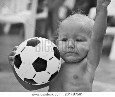Funny portrait of beautiful child with soccer ball. Cute little kid playing football.