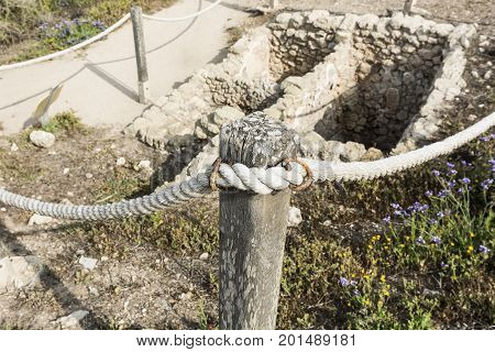 Ruins of the crusader fortress of the city Arsour fenced with a rope. Dunes on the shore of the Mediterranean sea in Israel. Spring flowers in the Israeli Apollonia national park.
