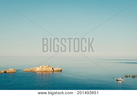 Fishing boat is overwhelmingly in the midst of the sea. Ulcinj seascape view. Green coast of Adriatic sea. Montenegro.