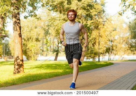 Young adult runner having intensive training outdoors in morning