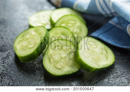 Sliced green cucumbers. Cucumber slices on black table.