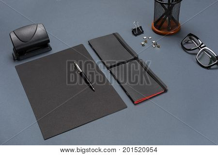 A set of black office accessories, glasses on gray background. Flat lay. Still life. Mock-up