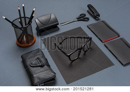 A set of black office accessories, glasses on gray background. Flat lay. Still life. Mock-up