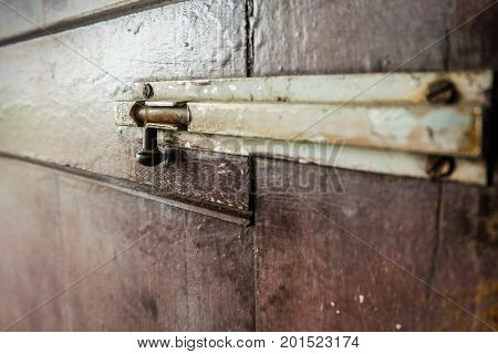 A latch of bar lock at the old wooden door. Protect Anti-theft Protection.