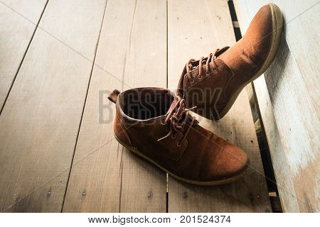 Brown vintage leather shoes on wooden floor.