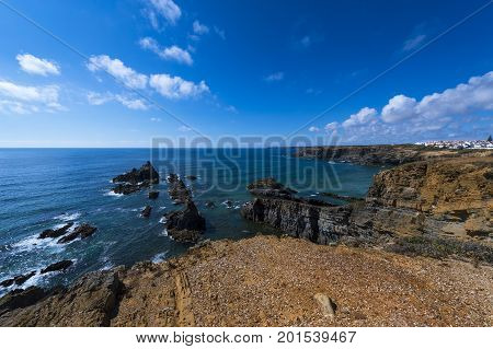 View of the cliffs and sea around the village of Zambujeira do Mar in Alentejo Portugal; Concept for travel in Portugal and summer vacations in Portugal