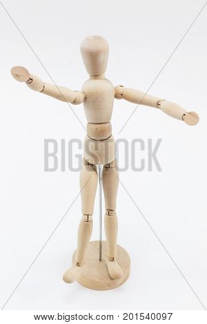 A wooden mannequin with open arms waiting to hug somebody on a white surface.