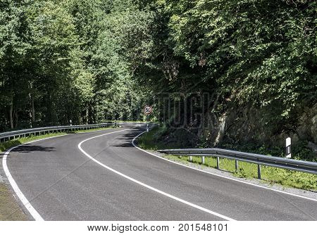 Country road in the forest concrete with speed limit signs of 50 km per hour sunny day
