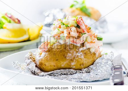 Swedish topped backed potato with shrimp on white background