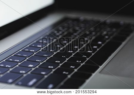 close up laptop keyboard illuminated on night