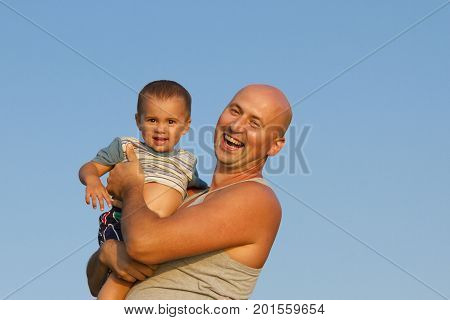 Father Plays And Has Fun With His Baby Daughter. Concept Photo Of Fatherhood, Newborn, Baby, Relatio