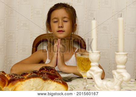 Jewish Girl Says The Blessing Upon Lighting The Sabbath Candles Before Shabbat Eve Dinner.