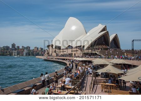 SYDNEY,NSW,AUSTRALIA-NOVEMBER 20,2016: Waterfront Opera Bar with crowds and the famous Sydney Opera House in Sydney, Australia