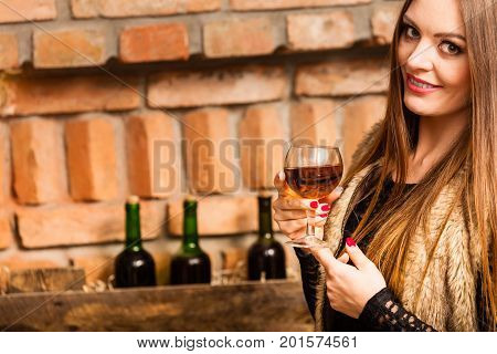 Woman Tasting Wine In Rural Cottage Interior