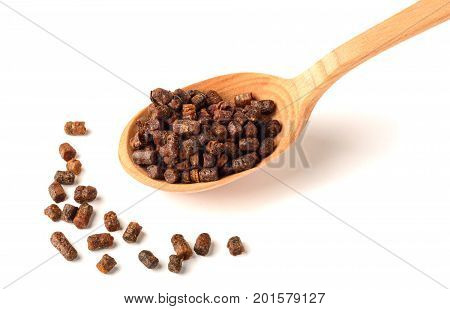Granules of bee bread in a wooden spoon are isolated on a white background. Apitherapy. Beekeeping products. Strengthening immunity