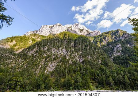 A beutiful landscape in the mountains, clouds above peaks and forest in foreground, European Alps, Robanov kot, Slovenia
