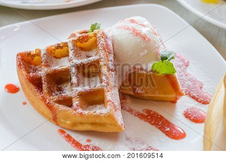Waffles with ice cream decorated with berry syrup