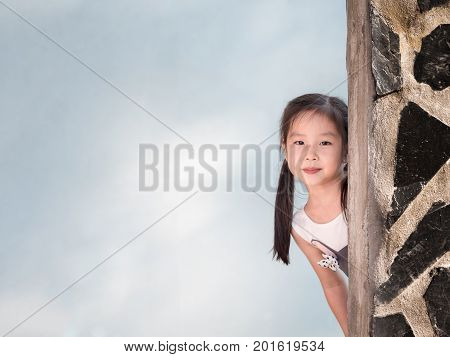 Asian girl hiding behind the wall peekaboo action