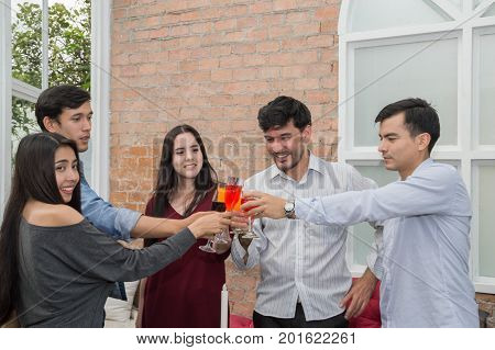 Young people holding glass talk in the party.