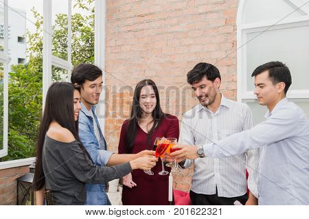Young people holding glass talk in the party.