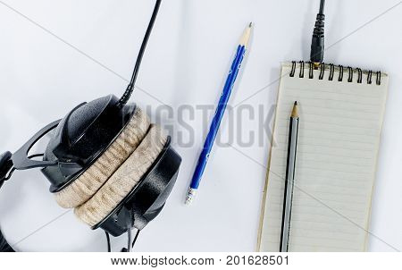 blank notebook in top view with music concept whitebackground headphones