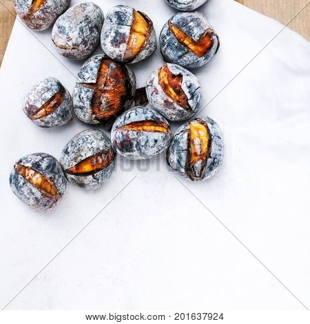 Roasted chestnuts with copy space. Delicious grilled chestnuts over white background