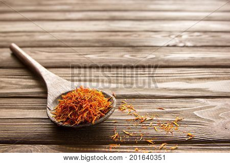 Spice saffron in a wooden spoon on the table. Close-up.