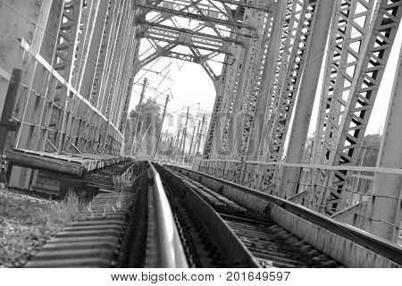 Railway metal bridge perspective view. Steel rail track. Black and white image