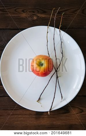 White Plate, Red Apple And Tree Brunches On A Wooden Background. Autumn, Thanksgiving, Halloween Con