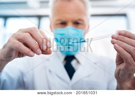 Keep concentration. Focused picture on male hands that holding pipette and piece of glass while going to do experiment