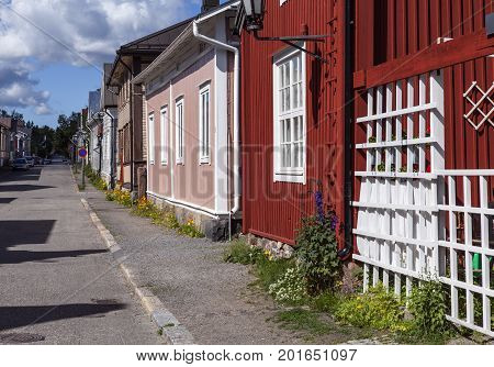 KOKKOLA, FINLAND ON JULY 07. Street view of wooden buildings, flowers, sidewalk on July 07, 2017 in Kokkola, Finland. Lamppost and signs. Editorial use.
