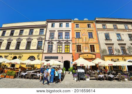 Lublin, Poland - August 10, 2017: Beautiful street and old colorful buildings in the old town of Lublin, Poland. Center of Lublin town. Old buildings and small street cafes at old Lublin town.