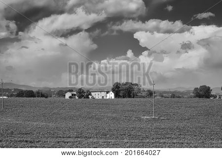 Country landscape at summer along the road from Fiorenzuola d'Arda to Castell'Arquato (Piacenza Emilia-Romagna Italy). Old farm house. Black and white