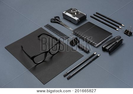 A set of black office accessories, glasses and old camera on gray background. Flat lay. Still life. Mock-up