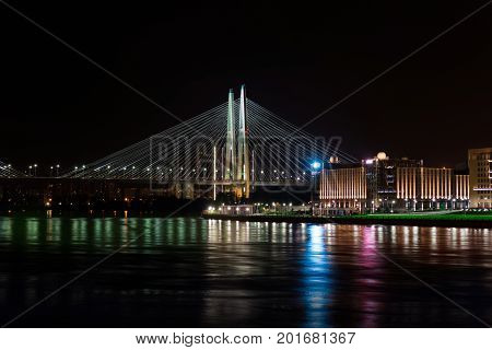 Saint Petersburg night view of the bridge and city lights across the river. View of the big Obukhov bridge from the October embankment.