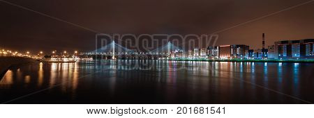 Panorama of the night city. Night lights of St. Petersburg. View of the big Obukhov bridge with a backlight across the river
